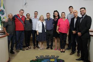#PraCegoVer: Foto oficial com todos os presentes na reunião em pé, no plenário da Câmara.