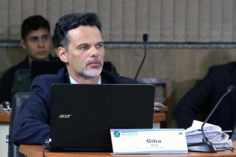 #PraCegoVer: Foto do vereador Giba sentado em sua mesa, acompanhando a sessão ordinária.