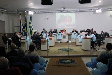 #PraCegoVer: Foto mostra o plenário da Câmara com os vereadores ao centro e parte do público presente nas laterais. O plenário está enfeitado com bexigas azuis, alusivas ao Dia Mundial de Conscientização do Autismo.